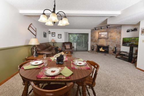 a living room with a table and a fireplace at Bearly Ober By Colonial Properties in Gatlinburg