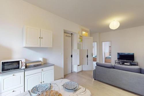 un salon avec un canapé et une table dans l'établissement Appartement T3 4 à 6 personnes, à Villeurbanne