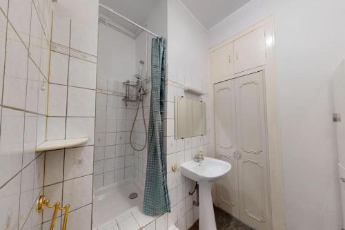 une salle de bain blanche avec un lavabo et une douche dans l'établissement Appartement T3 4 à 6 personnes, à Villeurbanne