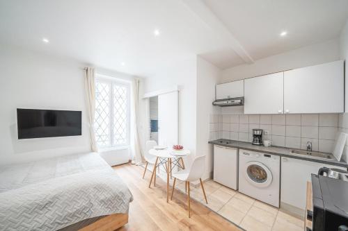 une chambre blanche avec un lit et une cuisine dans l'établissement Studio Roger - Montparnasse Paris 14th, à Paris