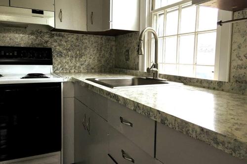 a white kitchen with a sink and a stove at Downtown, Near RISD & Train, Walk Everywhere in Providence