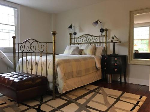 a bedroom with a bed and a chair and a mirror at Downtown, Near RISD & Train, Walk Everywhere in Providence