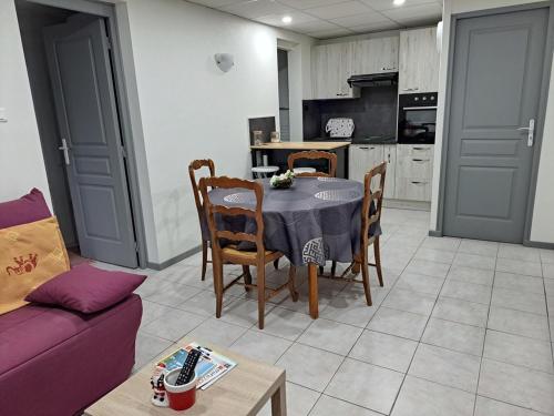 un salon avec une table et des chaises et une cuisine dans l'établissement Chez Patrick et Dominique, à Saint Pierre en Faucigny