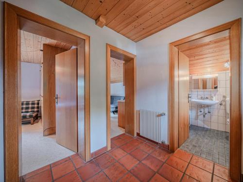 a hallway with a bathroom with a sink and a mirror at Jaklitsch XL in Alpendorf