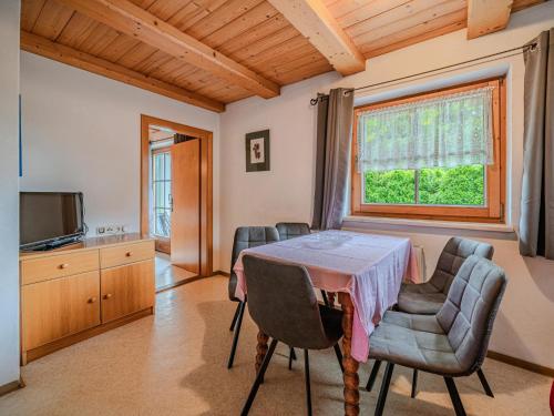 a dining room with a table and chairs and a window at Jaklitsch XL in Alpendorf