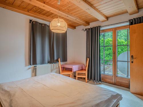 a bedroom with a bed and a table and a window at Jaklitsch XL in Alpendorf