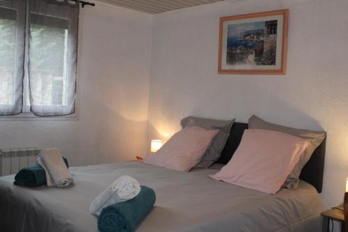 une chambre avec un lit avec des draps blancs et des oreillers dans l'établissement Chez Patrick et Dominique, à Saint Pierre en Faucigny