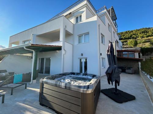 a large white house with a hot tub in front of it at Zana in Bol