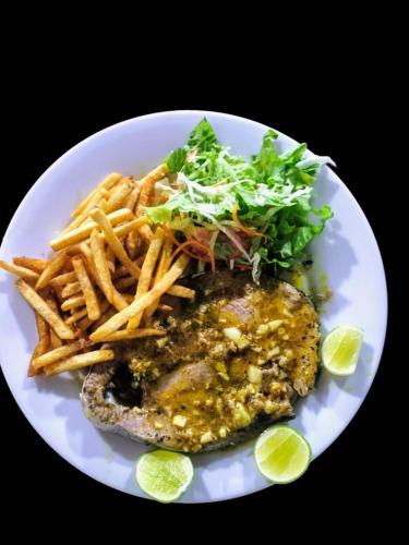 a plate of food with a burger and french fries at Hotel Coral Bay in Trincomalee