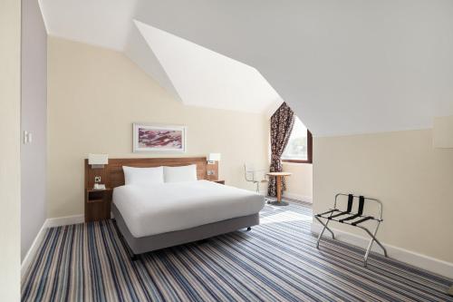 a hotel room with a bed and a chair at Holiday Inn Glasgow - East Kilbride by IHG in East Kilbride