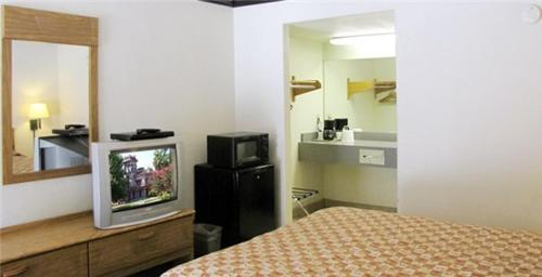 sypialnia z łóżkiem i telewizorem w obiekcie Town House Motel w mieście Chico
