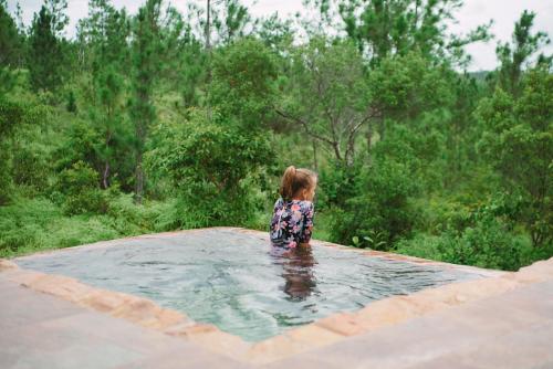 a little girl standing in a pool of water at Hidden Valley Wilderness Lodge in San Ignacio