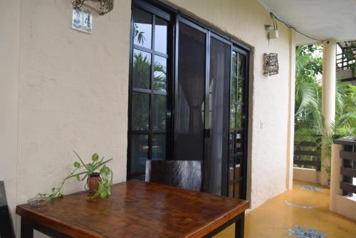 a dining room with a wooden table and large windows at Hotel Casa el Moro in Puerto Morelos