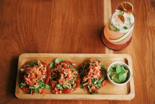 a wooden plate of food on a table with a drink at Hidden Valley Wilderness Lodge in San Ignacio