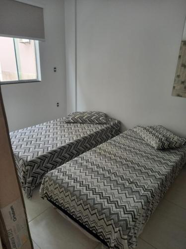two beds sitting next to each other in a room at Residencial Atalanta in Bombinhas