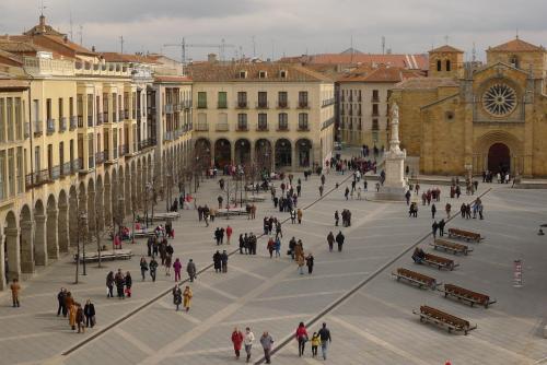 un grupo de personas caminando alrededor de una plaza de la ciudad en Hostal Doña Juana, en Ávila