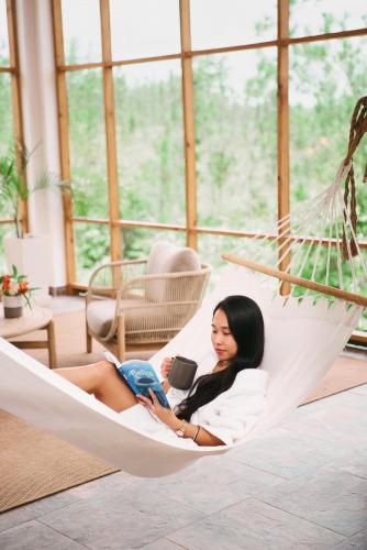 a woman laying in a hammock reading a book at Hidden Valley Wilderness Lodge in San Ignacio