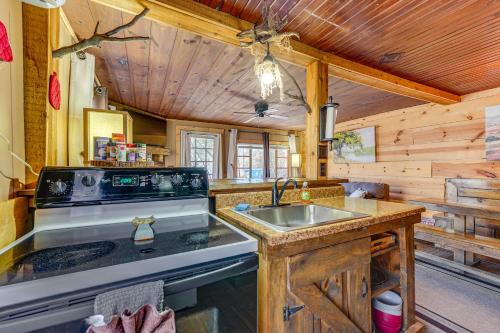 una cocina con fregadero y estufa en Branson Area Couples Cabin with Wraparound Porch!, en Rockaway Beach