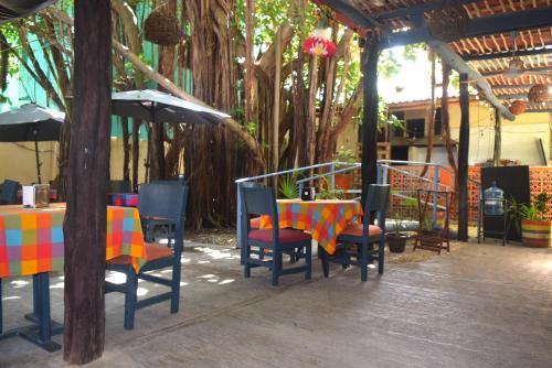 a patio with a table and chairs and umbrellas at Hotel Casa el Moro in Puerto Morelos