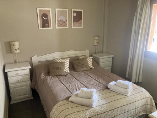 Un dormitorio con una cama con toallas. en Maitenes - Andarlibre, en San Martín de los Andes