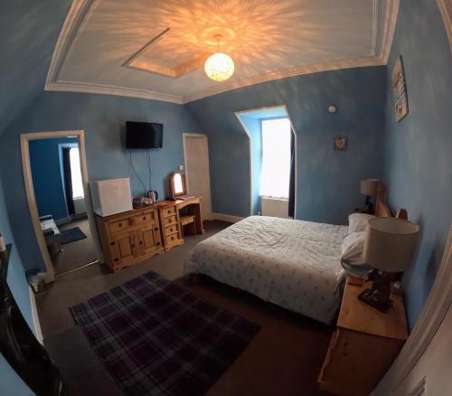 a bedroom with a bed and a tv and a ceiling at Bank House in Thurso
