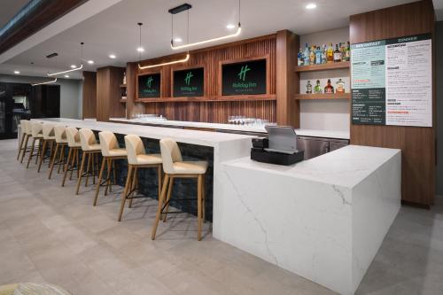 a bar in a restaurant with a row of stools at Holiday Inn La Verkin - Zion Park by IHG in La Verkin