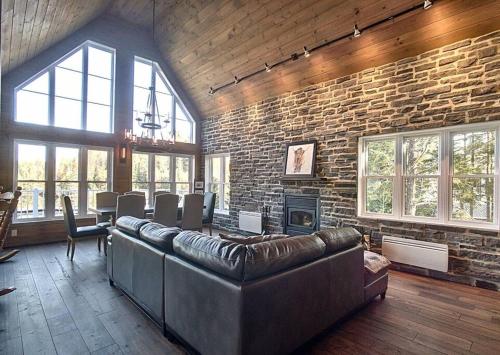 a living room with a couch and a brick wall at Formidable Waterfront Cottage - Formidable Chalet sur bord de l'eau in Saint Come