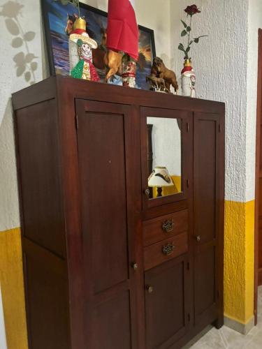 a wooden cabinet with a mirror on top of it at Casa Palagui Colonial in Valladolid