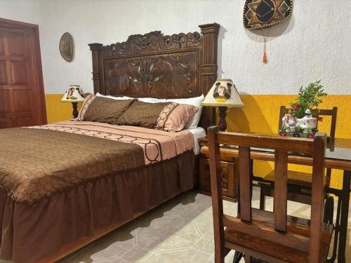 a bedroom with a bed and a table with two lamps at Casa Palagui Colonial in Valladolid