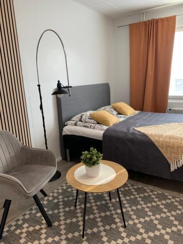 a bedroom with a bed and a chair and a table at Studio apartment B13 in the city center in Oulu