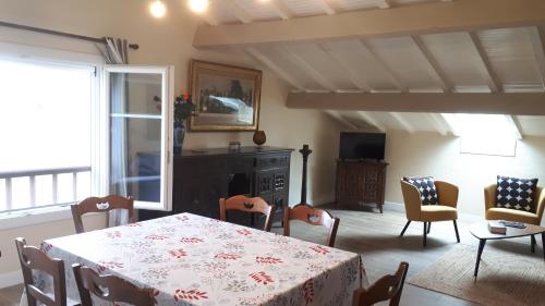 une salle à manger avec une table et des chaises et une cheminée dans l'établissement Maison GAINEKO ETXEA, à Ostabat-Asme