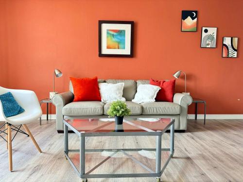 a living room with a couch and orange wall at Heart Downtown! City View Onsite Parking! King Bed LM807 in Atlanta