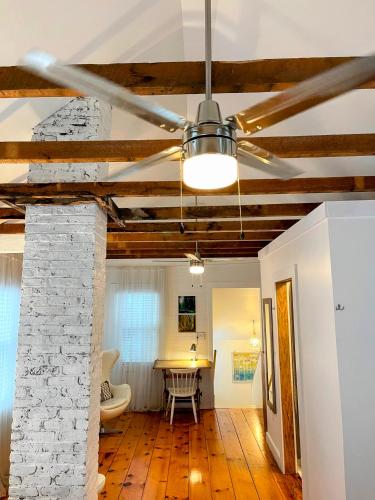 a living room with a ceiling fan and a table at An authentic, rustic luxurious little single family home in Old Town. All yours. in Marblehead