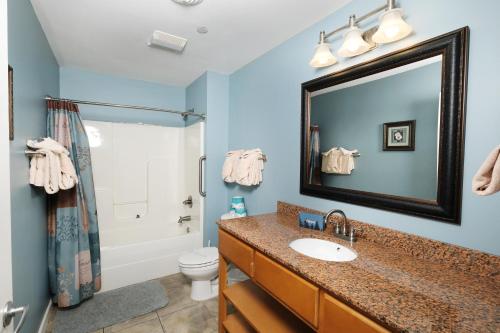 a bathroom with a sink and a toilet and a mirror at Still Waters in Pigeon Forge