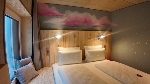 a bedroom with a bed with a painting on the wall at Villa Viva - ein Haus das Brunnen baut in Hamburg