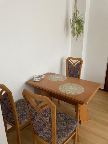 a wooden table with two chairs and a plant at Ferienwohnung im Ohmtal in Homberg an der Ohm