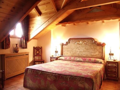 a bedroom with a large bed and a wooden ceiling at Hotel Posada Real in Aínsa