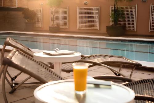 a drink on a table next to a swimming pool at Intercity Cuiabá in Cuiabá