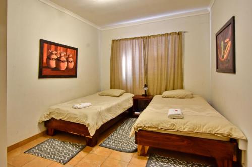 a bedroom with two beds and a window at Anandi Guesthouse Swakopmund in Swakopmund