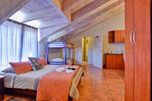 a bedroom with a bed and a kitchen in a room at Anandi Guesthouse Swakopmund in Swakopmund