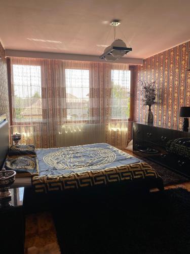 una camera da letto con un letto in una stanza con finestre di Vila Arcada Otp a Otopeni