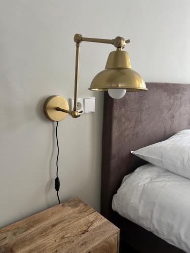 a lamp in a bedroom with a table next to a bed at Art Hotel Harlingen in Harlingen