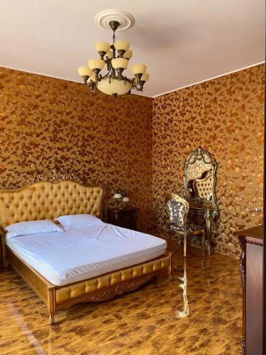 una camera da letto con un letto e un lampadario di Vila Arcada Otp a Otopeni