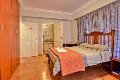 a small bedroom with a bed and a kitchen at Anandi Guesthouse Swakopmund in Swakopmund