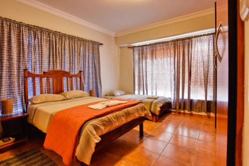 a bedroom with two beds and a window at Anandi Guesthouse Swakopmund in Swakopmund