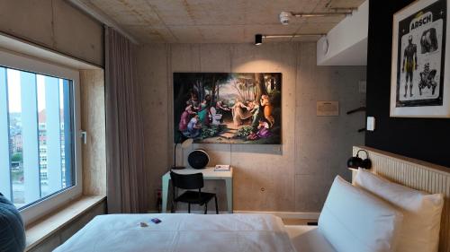 a hotel room with a bed and a painting on the wall at Villa Viva - ein Haus das Brunnen baut in Hamburg