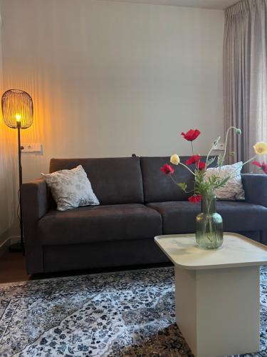 a living room with a couch and a table with flowers at Art Hotel Harlingen in Harlingen