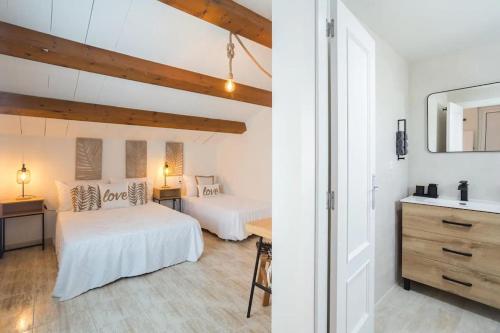 a bedroom with two beds and a sink in a room at Mediterranean Breeze Beach House in El Verger