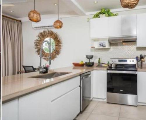 a kitchen with white cabinets and a counter top at Casa Margarita in Playa Flamingo