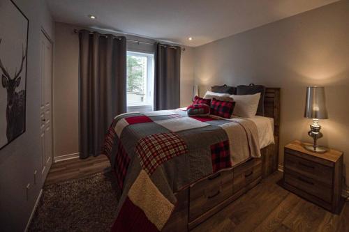 een slaapkamer met een bed en een raam bij Condo cottage-style Tremblant in Saint-Jovite